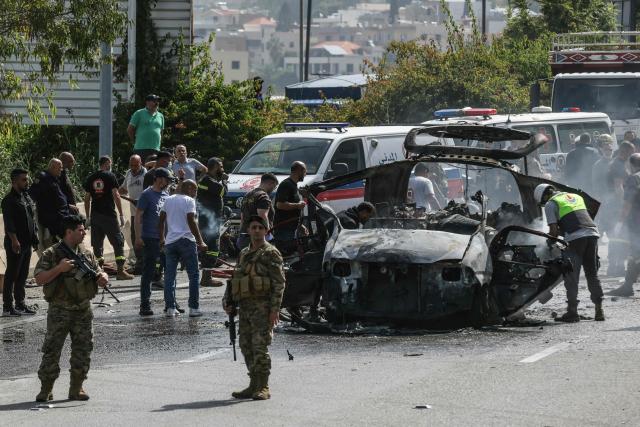 First responders intervene around a vehicle targeted by an Israeli drone strike on a highway near the town of Jiyeh, south of Beirut, on May 13, 2026. Israeli strikes targeted two cars on May 13 on a major highway linking Beirut to southern Lebanon, state media reported, despite a truce in the war between Israel and Hezbollah. (Photo by MAHMOUD ZAYYAT / AFP)