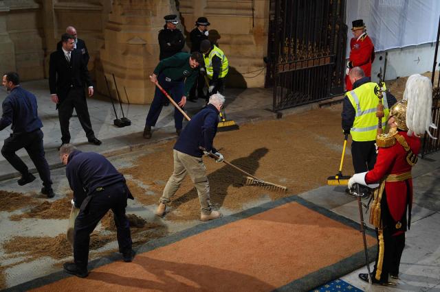 Sand is laid down ahead of the arrival of horses and carriages at the Sovereign's Entrance during the State Opening of Parliament at the Houses of Parliament, in London, on May 13, 2026. (Photo by Aaron Chown / POOL / AFP)