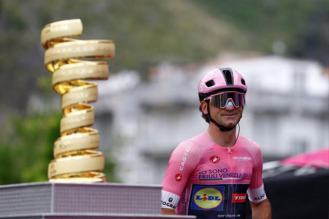 Lidl - Trek Italian rider Giulio Ciccone wearing the overall leader's pink jersey walks past the Giro d'Italia trophy ("trofeo senza fine") on the podium as he arrives ahead of the 5th stage of the Giro d'Italia 2026 - Tour of Italy cycling race between Praia a Mare and Potenza, southern Italy on May 13, 2026. (Photo by Luca Bettini / AFP)
