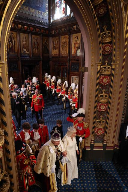 Britain's King Charles III, wearing the Imperial State Crown and the Robe of State, and Britain's Queen Camilla leave through the Royal Gallery during the State Opening of Parliament at the Houses of Parliament, in London, on May 13, 2026. (Photo by Adrian DENNIS / POOL / AFP)