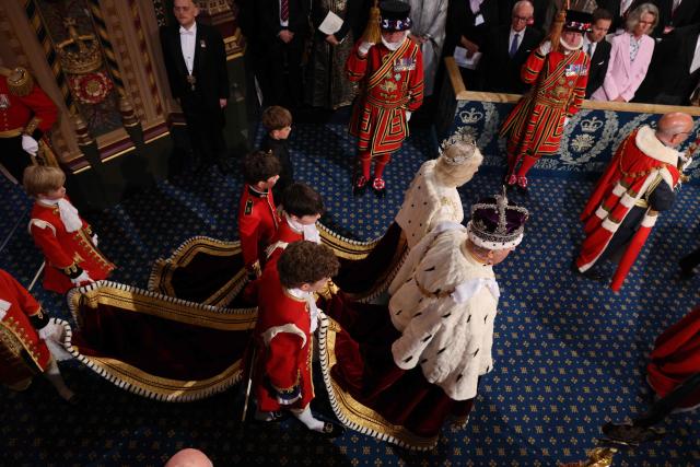 Britain's King Charles III, wearing the Imperial State Crown and the Robe of State, and Britain's Queen Camilla leave through the Royal Gallery during the State Opening of Parliament at the Houses of Parliament, in London, on May 13, 2026. (Photo by Adrian DENNIS / POOL / AFP)