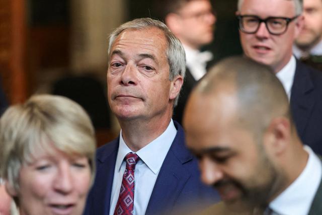 Reform UK leader Nigel Farage (C) walks through the House of Commons to attend the State Opening of Parliament at the Palace of Westminster in London on May 13, 2026. (Photo by Toby Melville / POOL / AFP)