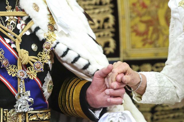 Britain's King Charles III holds Britain's Queen Camilla hand after making his speech in the House of Lords chamber, during the State Opening of Parliament, at the Houses of Parliament, in London on May 13, 2026. (Photo by Chris Jackson / POOL / AFP)