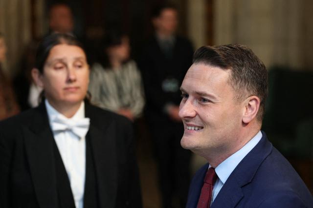 Britain's Health Secretary Wes Streeting (R) walks through the House of Commons to attend the State Opening of Parliament at the Palace of Westminster in London on May 13, 2026. (Photo by Toby Melville / POOL / AFP)