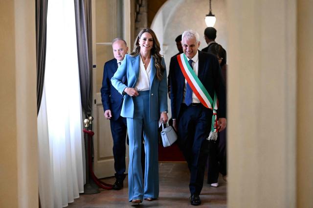 Britain's Catherine, Princess of Wales walks along with the mayor of Reggio Emilia, Marco Massari, at Reggio Emilia's town hall as part of a two-day visit in Italy, on May 13, 2026. (Photo by Marco BERTORELLO / POOL / AFP)