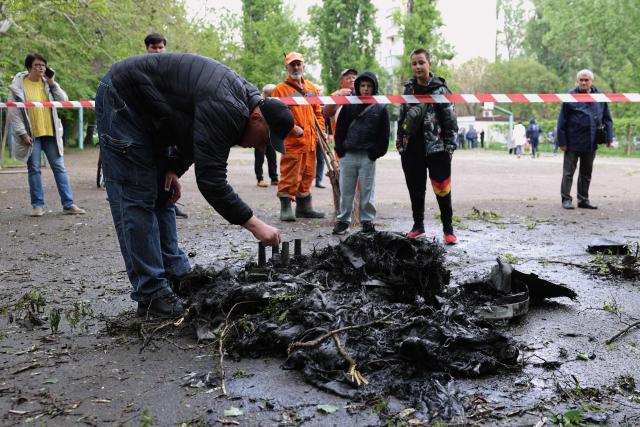 A man inspects fragments of a drone in the courtyard of a residential building following an air attack in Odesa on May 13, 2026, amid the Russian invasion in Ukraine. (Photo by Oleksandr GIMANOV / AFP)