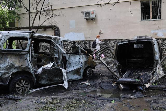 A woman walks past destroyed cars in the courtyard of a damaged residential building following an air attack in Odesa on May 13, 2026, amid the Russian invasion in Ukraine. (Photo by Oleksandr GIMANOV / AFP)