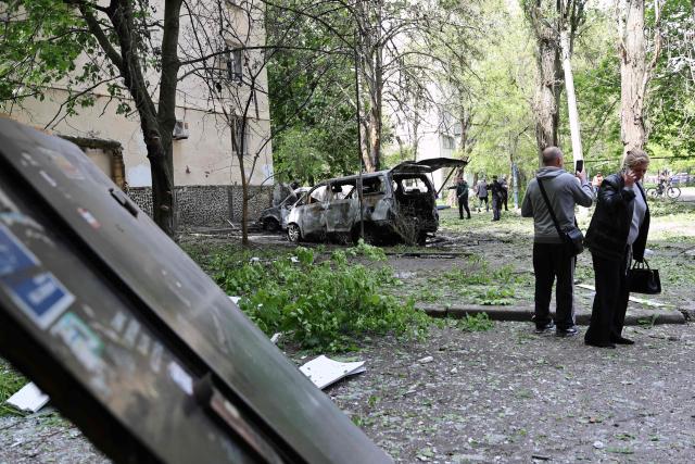Local residents stand next to destroyed cars in the courtyard of a damaged residential building following an air attack in Odesa on May 13, 2026, amid the Russian invasion in Ukraine. (Photo by Oleksandr GIMANOV / AFP)