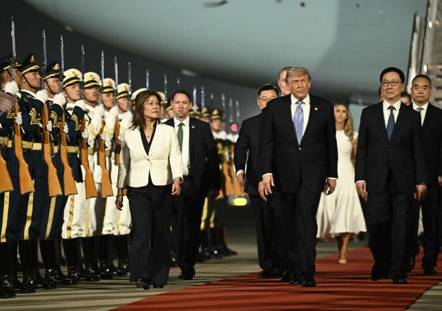 TOPSHOT - US President Donald Trump (C) is escorted by China's Vice President Han Zheng (R) upon his arrival at Beijing Capital Airport in Beijing on May 13, 2026. (Photo by Brendan SMIALOWSKI / AFP)