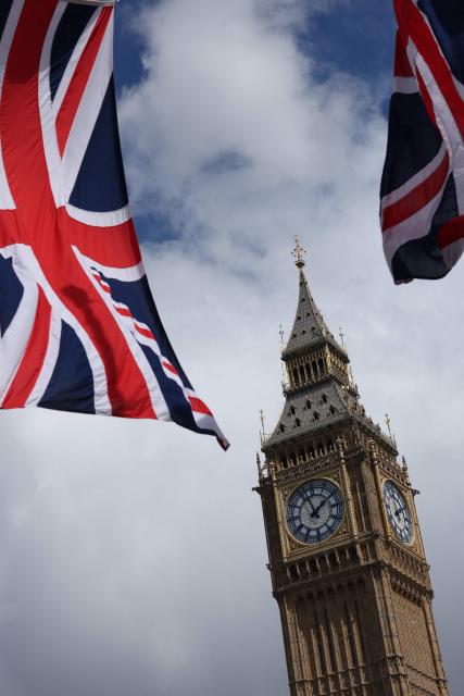Union flags flutter in the breeze close to the Elizabeth Tower, commonly known by the name of the clock's bell "Big Ben", after the State Opening of Parliament at the Palace of Westminster in London on May 13, 2026. (Photo by Adrian DENNIS / AFP)
