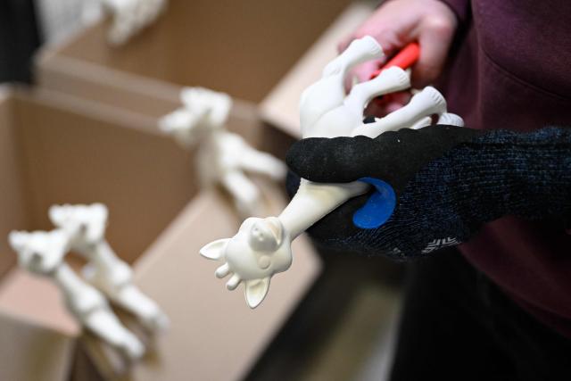 An employee works on the production of Sophie la girafe (Sophie the Giraffe) toys made by French baby care products and toys company Vulli in its new production site in Saint-Nabord, north-eastern France, on May 12, 2026. Vulli, which has made "Made in France" its hallmark, has admitted on May 4, 2026 manufacturing giraffe toys in China, as revealed in an investigation by the online media outlet Mediapart, but insists that this is a temporary situation. The French Directorate-General for Competition, Consumer Affairs and Fraud Control (DGCCRF) has launched an investigation as claiming a product to be of French origin when it is not may constitute a misleading commercial practise, punishable by a criminal fine of up to 10% of turnover. (Photo by Jean-Christophe VERHAEGEN / AFP)