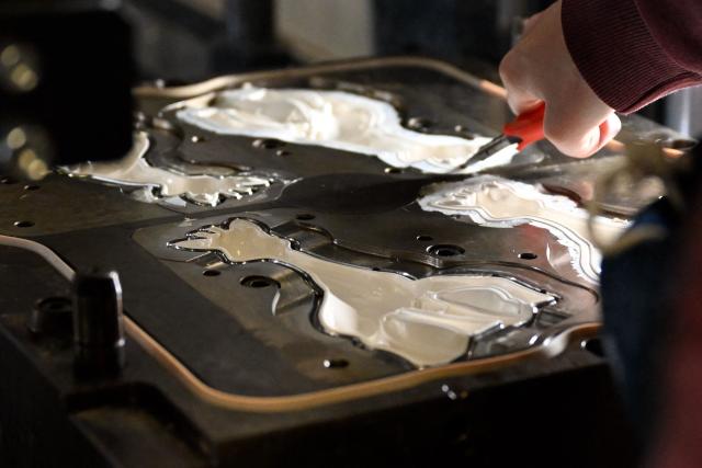 An employee works on the production of Sophie la girafe (Sophie the Giraffe) toys made by French baby care products and toys company Vulli in its new production site in Saint-Nabord, north-eastern France, on May 12, 2026. Vulli, which has made "Made in France" its hallmark, has admitted on May 4, 2026 manufacturing giraffe toys in China, as revealed in an investigation by the online media outlet Mediapart, but insists that this is a temporary situation. The French Directorate-General for Competition, Consumer Affairs and Fraud Control (DGCCRF) has launched an investigation as claiming a product to be of French origin when it is not may constitute a misleading commercial practise, punishable by a criminal fine of up to 10% of turnover. (Photo by Jean-Christophe VERHAEGEN / AFP)