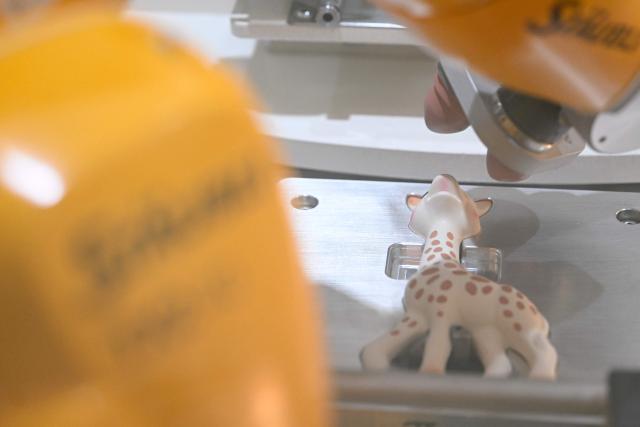 This photograph shows a Sophie la girafe (Sophie the Giraffe) toy made by French baby care products and toys company Vulli in the production line's painting booth of its new production site in Saint-Nabord, north-eastern France, on May 12, 2026. Vulli, which has made "Made in France" its hallmark, has admitted on May 4, 2026 manufacturing giraffe toys in China, as revealed in an investigation by the online media outlet Mediapart, but insists that this is a temporary situation. The French Directorate-General for Competition, Consumer Affairs and Fraud Control (DGCCRF) has launched an investigation as claiming a product to be of French origin when it is not may constitute a misleading commercial practise, punishable by a criminal fine of up to 10% of turnover. (Photo by Jean-Christophe VERHAEGEN / AFP)