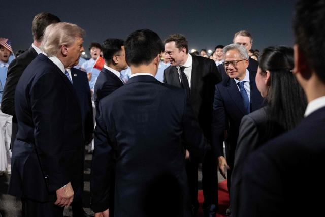 US President Donald J. Trump watches as members of his delegation including Tesla and SpaceX's CEO Elon Musk and Nvidia President and CEO Jensen Huang are greeted by China's Vice President Han Zheng and others as they arrive at the Beijing Capital International Airport May 13, 2026. (Photo by Brendan Smialowski / AFP)