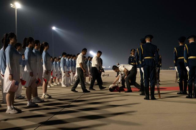 Chinese youth and officials prepare for the arrival of US President Donald J. Trump at the Beijing Capital International Airport May 13, 2026. (Photo by Brendan Smialowski / AFP)