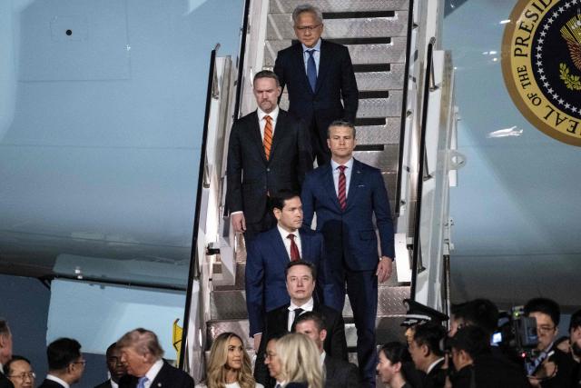 Tesla and SpaceX's CEO Elon Musk, US Secretary of State Marco Rubio, US Secretary of Defence Pete Hegseth, US Trade Representative Jamieson Greer and Nvidia President and CEO Jensen Huang follow US President Donald J. Trump as he is greeted by China's Vice President Han Zheng and others as he arrives at the Beijing Capital Airport in Beijing on May 13, 2026. (Photo by Brendan SMIALOWSKI / AFP)