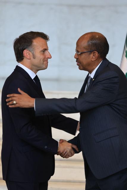 France's President Emmanuel Macron (L) shakes hands with African Union Commission's President Mahamoud Ali Youssouf (R) during a press conference at the African Union (AU) headquarters in Addis Ababa on May 13, 2026. (Photo by Ludovic MARIN / AFP)