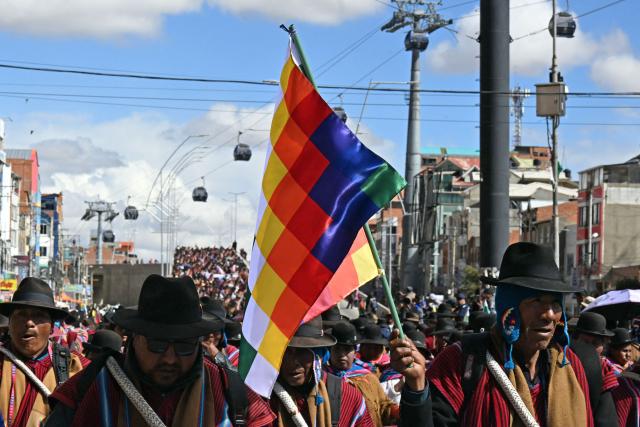 Indigenous people from the "Ponchos Rojos" union march from El Alto to La Paz during a protest against the government of Bolivian President Rodrigo Paz, on May 13, 2026. For the past two weeks, workers, farmers, school teachers, Indigenous groups and transport workers have been pressuring the government. Their demands range from wage increases and economic stabilization to opposition to the privatization of public companies. (Photo by AIZAR RALDES / AFP)
