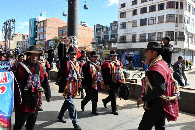 Indigenous people from the "Ponchos Rojos" union march from El Alto to La Paz during a protest against the government of Bolivian President Rodrigo Paz, on May 13, 2026. For the past two weeks, workers, farmers, school teachers, Indigenous groups and transport workers have been pressuring the government. Their demands range from wage increases and economic stabilization to opposition to the privatization of public companies. (Photo by AIZAR RALDES / AFP)