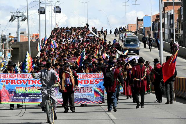 Indigenous people from the "Ponchos Rojos" union march from El Alto to La Paz during a protest against the government of Bolivian President Rodrigo Paz, on May 13, 2026. For the past two weeks, workers, farmers, school teachers, Indigenous groups and transport workers have been pressuring the government. Their demands range from wage increases and economic stabilization to opposition to the privatization of public companies. (Photo by AIZAR RALDES / AFP)