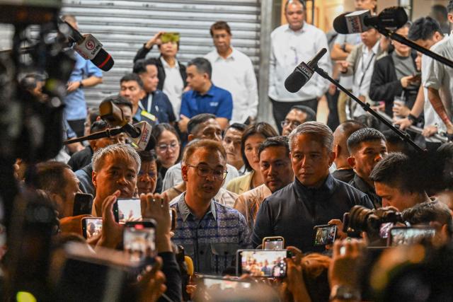 Philippine senators who got trapped speak to the media after the exchange of gunshots inside the Senate of the Philippines in Pasay, Metro Manila on May 13, 2026. Multiple gunshots sent Philippine senators into hiding in their offices late on May 13, AFP journalists said, as a legislator wanted by the International Criminal Court has sought refuge in the building. (Photo by Jam STA ROSA / AFP)