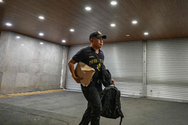 A member of the Scene of the Crime Operatives (SOCO) arrives after the exchange of gunshots inside the Senate of the Philippines in Pasay, Metro Manila on May 13, 2026. Multiple gunshots sent Philippine senators into hiding in their offices late on May 13, AFP journalists said, as a legislator wanted by the International Criminal Court has sought refuge in the building. (Photo by Jam STA ROSA / AFP)