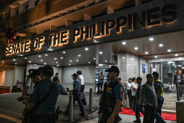 Police personnel arrive outside the Senate of the Philippines in Pasay, Metro Manila on May 13, 2026. Multiple gunshots sent Philippine senators into hiding in their offices late on May 13, AFP journalists said, as a legislator wanted by the International Criminal Court has sought refuge in the building. (Photo by Jam STA ROSA / AFP)