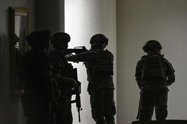 Philippine troops exchange gunshots inside the Senate of the Philippines in Pasay, Metro Manila on May 13, 2026. Multiple gunshots sent Philippine senators into hiding in their offices late on May 13, AFP journalists said, as a legislator wanted by the International Criminal Court has sought refuge in the building. (Photo by Jam STA ROSA / AFP)