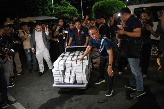 Workers push a trolley loaded with documents of articles of impeachment at the Senate premises from the House of Representatives in Manila on May 13, 2026. Philippine lawmakers voted on May 11 by a wide margin to impeach Vice President Sara Duterte for the second time, setting the stage for a Senate trial that could end her 2028 presidential bid. (Photo by Ted ALJIBE / AFP)