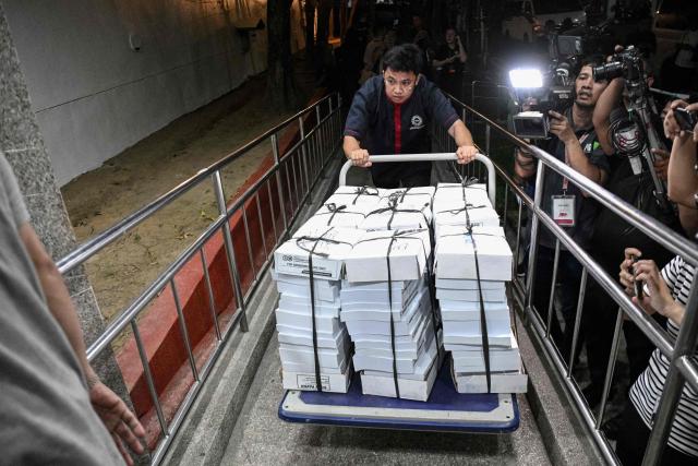 A worker pushes a trolley loaded with documents of articles of impeachment at the Senate premises from the House of Representatives in Manila on May 13, 2026. Philippine lawmakers voted on May 11 by a wide margin to impeach Vice President Sara Duterte for the second time, setting the stage for a Senate trial that could end her 2028 presidential bid. (Photo by Ted ALJIBE / AFP)