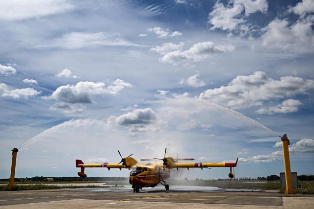 A Canadair water-bomber aircraft is cleaned afterwards to prevent corrosion from salt water at the Nimes-Garons firefighters air base in Garons, southern France, on May 13, 2026 (Photo by Gabriel BOUYS / AFP)