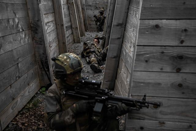 French Foreign Legion paratroopers from the 2nd Foreign Parachute Regiment (2e REP) take part in a trench combat exercise, one holding position inside the trench network while another lies on the ground after being declared a casualty, during exercise LIBECCIU 2026, in La Courtine, central France, on May 13, 2026. More than 700 légionnaires are deployed across two French regions for the ten-day field exercise, sharpening the night-warfare and rapid-redeployment skills that define the Legion's airborne identity. (Photo by Philippe LOPEZ / AFP)