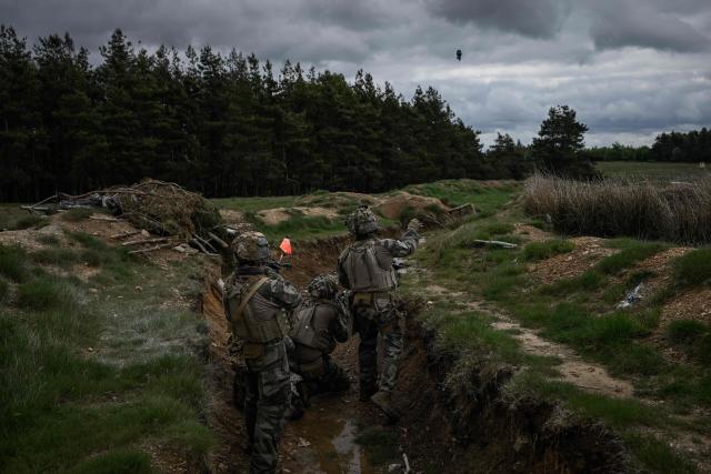 A French Foreign Legion paratrooper from the 2nd Foreign Parachute Regiment (2e REP) trows a training grenade as he takes part in a trench assault during exercise LIBECCIU 2026, in La Courtine, central France, on May 13, 2026. More than 700 légionnaires are deployed across two French regions for the ten-day field exercise, sharpening the night-warfare and rapid-redeployment skills that define the Legion's airborne identity. (Photo by Philippe LOPEZ / AFP)