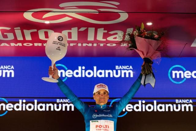 Team Polti VisitMalta Spanish rider Diego Sevilla, wearing the best climber's blue jersey (Maglia Azzura), celebrates on the podium after the 5th stage of the Giro d'Italia 2026 - Tour of Italy cycling race between Praia a Mare and Potenza, southern Italy on May 13, 2026. (Photo by Luca BETTINI / AFP)