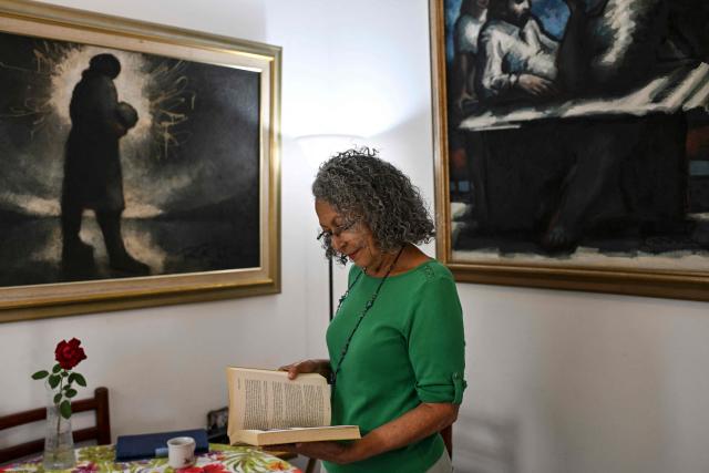 Former Sandinista National Liberation Front (FSLN) guerrilla commander Monica Baltodano reads one of her books in the living room during an interview with AFP at her home in San Jose on May 10, 2026. Nicaragua’s co-president, Rosario Murillo, will not remain in power after Daniel Ortega’s death, said former guerrilla commander Baltodano in an interview with AFP whilst in exile in Costa Rica. (Photo by MARTIN BERNETTI / AFP)