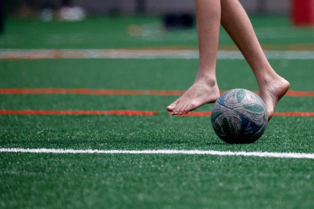 A man controls a soccer ball with his bare feet at Harvey Field in Kearny, New Jersey on May 9, 2026. Anthony Duro had hoped the World Cup coming to his soccer-mad New Jersey town would mean watching games at nearby MetLife Stadium, but sky-high ticket prices are beyond his budget. (Photo by Leonardo MUNOZ / AFP) / TO GO WITH AFP STORY BY BEN TURNER