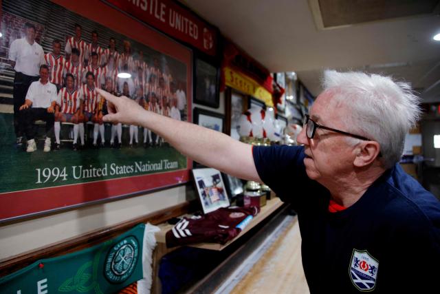 Andrew Pollock, CEO of the Scots American Club points some players in a picture at the Scots American Club in Kearny, New Jersey on May 9, 2026. Anthony Duro had hoped the World Cup coming to his soccer-mad New Jersey town would mean watching games at nearby MetLife Stadium, but sky-high ticket prices are beyond his budget. (Photo by Leonardo MUNOZ / AFP) / TO GO WITH AFP STORY BY BEN TURNER