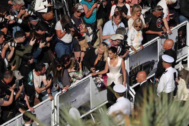 President of the jury "Un Certain Regard" and French actress Leila Bekhti (C-R) pose for a photo with a fan as she arrives for the screening of the film "La Vie d'une femme" (A Woman's Life) at the 79th edition of the Cannes Film Festival in Cannes, southern France on May 13, 2026. (Photo by Sameer AL-DOUMY / AFP)