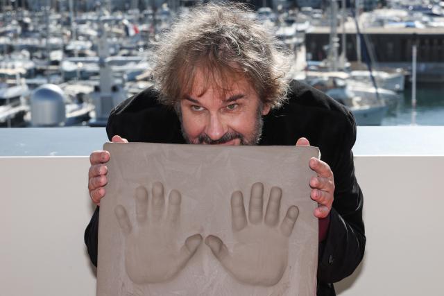 New Zealand director, screenwriter and producer Peter Jackson displays his handprints during an induction ceremony at the Cafe des Palmes at the Palais des Festivals during the 79th edition of the Cannes Film Festival in Cannes, southern France on May 13, 2026. (Photo by Valery HACHE / AFP)