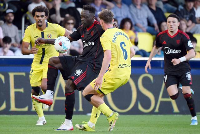 Sevilla's Nigerian forward #09 Akor Jerome Adams (2L) is challenged by Villarreal's Spanish defender #06 Pau Navarro during the Spanish league football match between Villarreal CF and Sevilla FC at La Ceramica Stadium in Vila-real on May 12, 2026. (Photo by JOSE JORDAN / AFP)