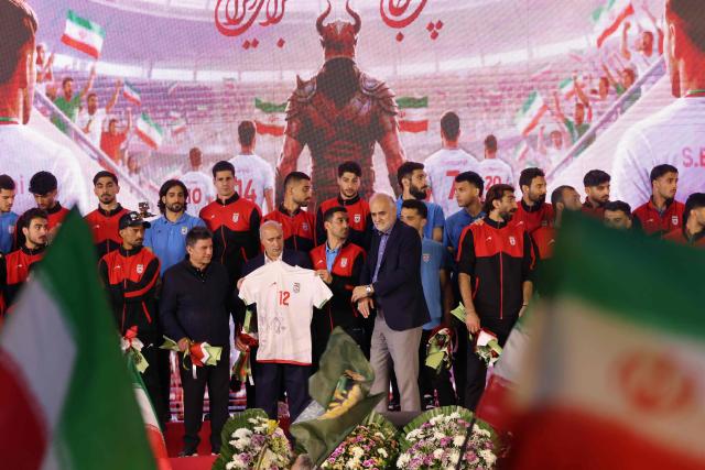 Members of Iran's national football team attend a farewell ceremony ahead of their departure for the 2026 FIFA World Cup, in Tehran on May 13, 2026. The president of the Iranian Football Federation said late May 9 that if Iran dropped out of the World Cup, it would deprive the country of a "major diplomatic asset". World football's governing body FIFA has insisted for weeks that Iran will take part. Iran, who are due to be based in Tucson, Arizona, during the World Cup, face New Zealand, Belgium and Egypt in Group G. The Iranians open their World Cup campaign against New Zealand in Los Angeles on June 15. (Photo by ATTA KENARE / AFP)