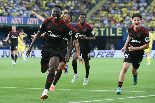 Sevilla's Nigerian forward #09 Akor Jerome Adams (L) celebrates scoring his team's third goal during the Spanish league football match between Villarreal CF and Sevilla FC at La Ceramica Stadium in Vila-real on May 12, 2026. (Photo by JOSE JORDAN / AFP)