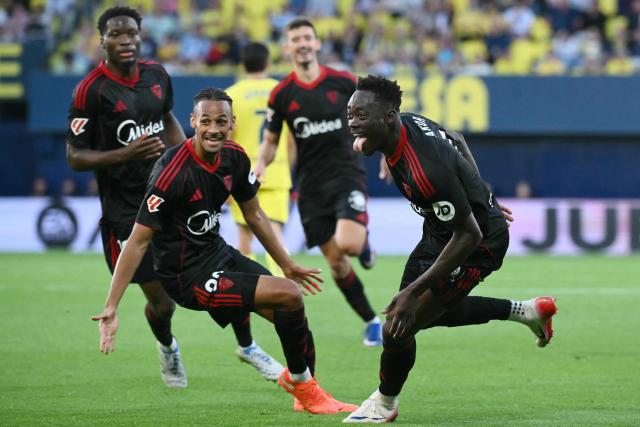 Sevilla's Nigerian forward #09 Akor Jerome Adams (R) celebrates scoring his team's third goal during the Spanish league football match between Villarreal CF and Sevilla FC at La Ceramica Stadium in Vila-real on May 12, 2026. (Photo by JOSE JORDAN / AFP)