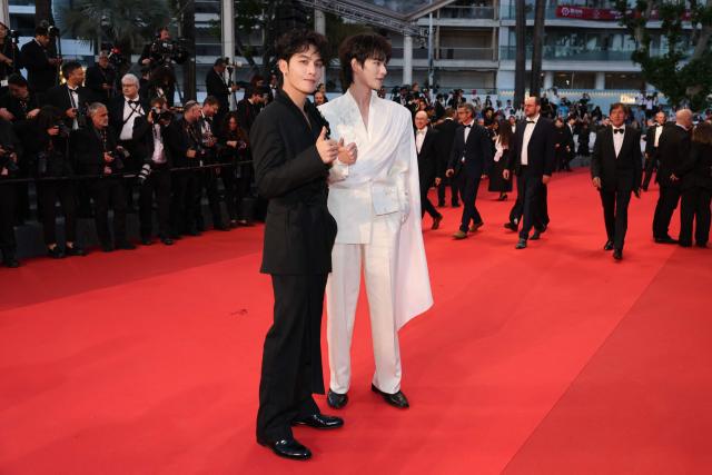 Chinese actor and musician He Yan Chao (L) and Chinese actor and singer He Changxi arrive for the screening of the film "L'Abandon" at the 79th edition of the Cannes Film Festival in Cannes, southern France on May 13, 2026. (Photo by Thibaud MORITZ / AFP)