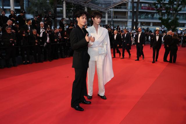 Chinese actor and musician He Yan Chao (L) and Chinese actor and singer He Changxi arrive for the screening of the film "L'Abandon" at the 79th edition of the Cannes Film Festival in Cannes, southern France on May 13, 2026. (Photo by Thibaud MORITZ / AFP)