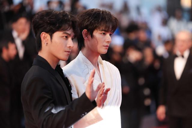 Chinese actor and musician He Yan Chao (L) and Chinese actor and singer He Changxi arrive for the screening of the film "L'Abandon" at the 79th edition of the Cannes Film Festival in Cannes, southern France on May 13, 2026. (Photo by Thibaud MORITZ / AFP)