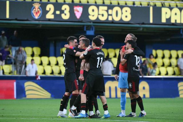Sevilla players celebrate at the end of the Spanish league football match between Villarreal CF and Sevilla FC at La Ceramica Stadium in Vila-real on May 12, 2026. (Photo by JOSE JORDAN / AFP)