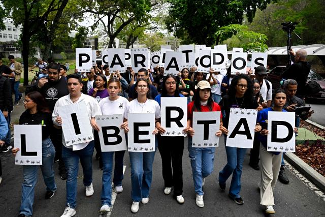 Students and relatives of political prisoners hold signs whose letters spell out the word in Spanish, "Freedom," as they take part in a protest calling for their release outside the Central University of Venezuela (UCV) in Caracas on May 13, 2026. College students and their families blocked the main highway in Caracas on May 13, to protest the forced disappearance of some 50 political prisoners in Venezuela and the deaths in custody of about 20 detainees over the past decade. (Photo by Federico PARRA / AFP)