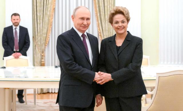 In this pool photograph distributed by the Russian state agency Sputnik, Russia's President Vladimir Putin meets with Dilma Rousseff, former Brazil president and current president of the New Development Bank, at the Kremlin in Moscow on May 13, 2026. (Photo by Pelagia Tikhonova / POOL / AFP)