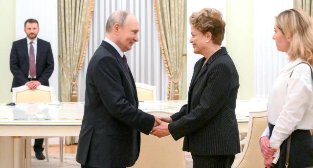 In this pool photograph distributed by the Russian state agency Sputnik, Russia's President Vladimir Putin meets with Dilma Rousseff, former Brazil president and current president of the New Development Bank, at the Kremlin in Moscow on May 13, 2026. (Photo by Pelagia Tikhonova / POOL / AFP)